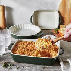 a casserole dish with bread and vegetables in it, on a wooden table