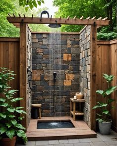 an outdoor shower is shown in the middle of a garden with wooden benches and potted plants