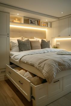 a bed with two drawers underneath it in a room that has wood floors and white walls