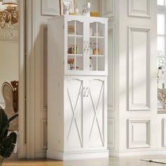 a tall white cabinet sitting in the middle of a room