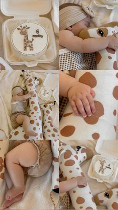 a baby laying on top of a bed with giraffes and other items