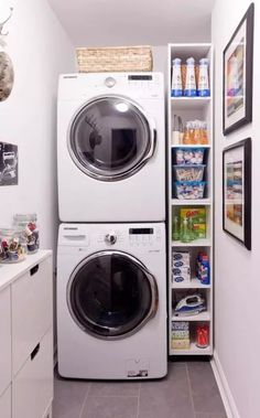 a white washer and dryer in a small room with shelves on the wall