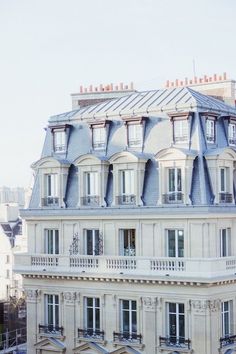 an apartment building with many windows and balconies on the top floor, in paris