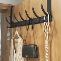 several purses and handbags are hanging on a coat rack