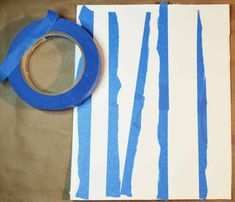 tape is being used to make a striped wallpaper pattern with white and blue strips