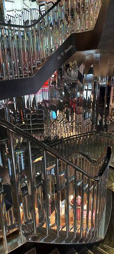 a spiral staircase in a large building with lots of glass balconies and railings