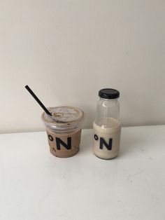 a cup of coffee next to a jar with the word n on it