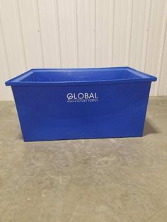 a large blue plastic container sitting on top of a cement floor next to a white wall