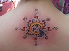 a woman's back with a sun and moon tattoo on her upper back shoulder