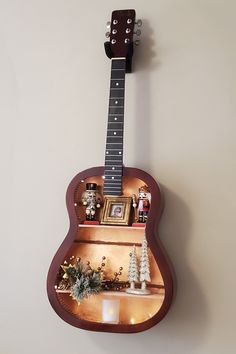 a guitar shaped shelf with christmas decorations on it