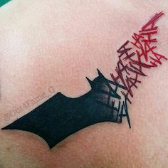 a bat tattoo on the back of a man's shoulder with writing all over it