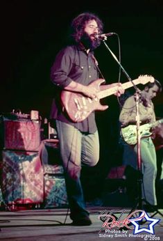 two men are playing guitars on stage