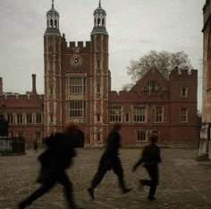 three people are running in front of a building