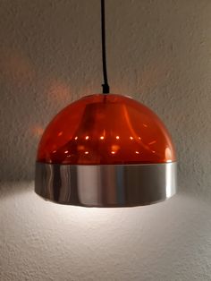 an orange light hanging from a ceiling in a room