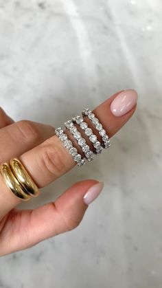 a woman's hand with five rings on her finger and one ring in the middle