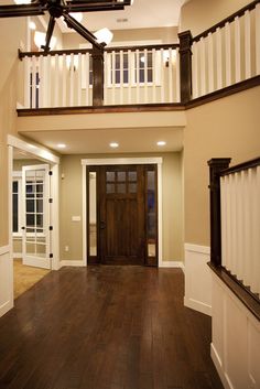 an open floor plan with wood floors and white railings