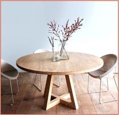 a wooden table with chairs around it and a vase filled with flowers on the table