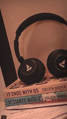 headphones sitting on top of some books