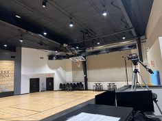 an empty basketball court with chairs and microphones