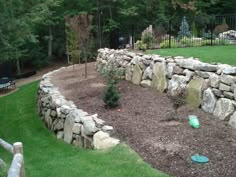 a stone wall in the middle of a yard