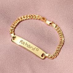 a gold chain bracelet that says richard and is engraved with the name of his son