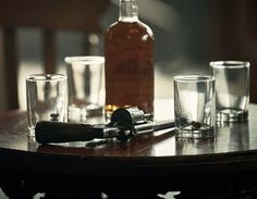 a wooden table topped with glasses and bottles