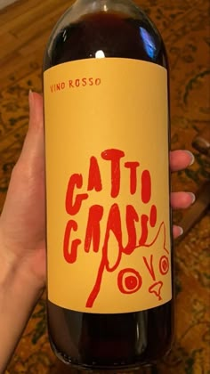 a person holding up a bottle of cat gravy