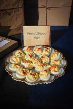 deviled eggs are arranged on a platter next to a box of chocolates