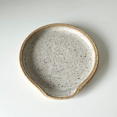 a white and black speckled bowl sitting on top of a table