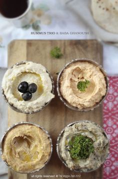 hummus trio and baba ghanousi on a cutting board with olives