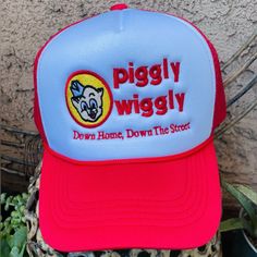 the piggly wiggly trucker hat is sitting on top of a leopard print plant