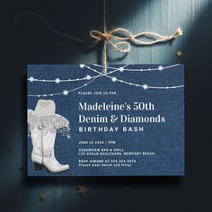 an image of a birthday party card with boots and stars on the front, string lights in the background