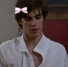 a young man wearing a white shirt and pink bow tie