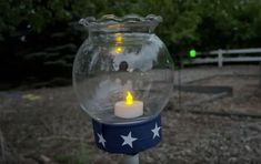 a lit candle in a glass jar with stars on it