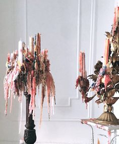 two lamps with pink and gold ribbons hanging from them on top of a white table