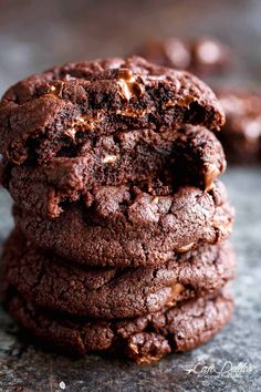 a stack of chocolate cookies sitting on top of a table next to another cookie in the background