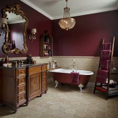 a bathroom with a claw foot bathtub, sink and mirror