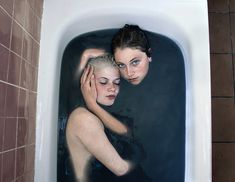 two women in a bathtub with their arms around each other