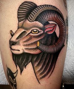 a ram tattoo on the leg of a man's arm, with an arrow in his ear