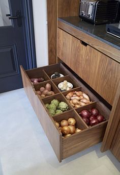 an open drawer in a kitchen filled with assorted fruits and vegetables