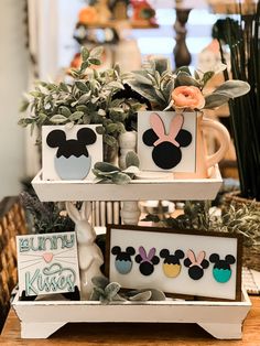 three tiered trays with mickey mouse and bunny ears on them, each holding greeting cards