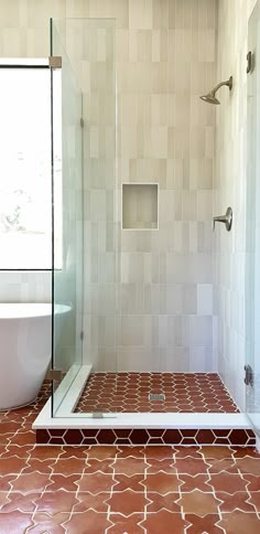 a bathroom with tiled flooring and a walk in shower next to a bathtub