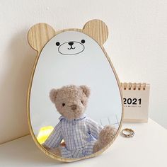 a teddy bear sitting in front of a mirror