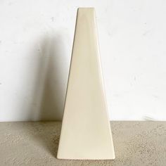 a white vase sitting on top of a cement floor