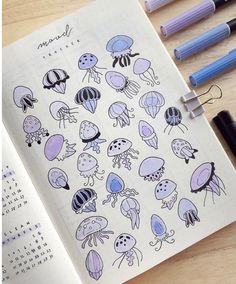 an open notebook with jellyfish stickers on it and some markers next to it