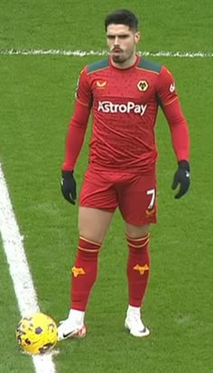 a man standing on top of a soccer field next to a yellow and black ball