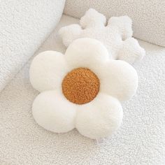 a stuffed flower sitting on top of a white couch