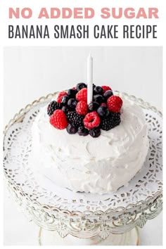 a white cake with berries and raspberries on top is sitting on a plate