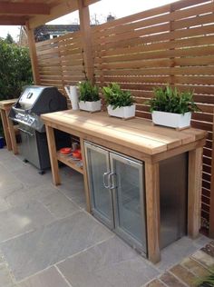 an outdoor grill with potted plants on top