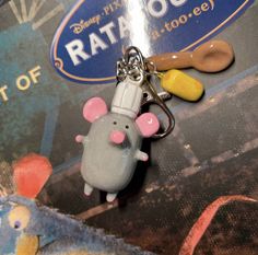 a keychain with a mouse on it and a toothbrush in the shape of a rat